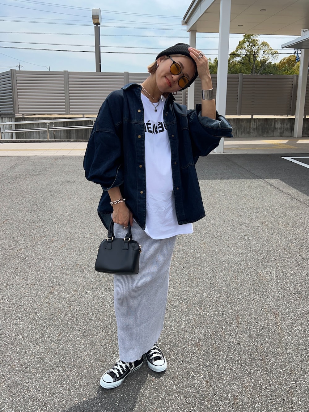 ホワイト系のTシャツ/カットソー、ブラック系のボストンバッグ、グレー系のスカートを着用したレディースの春コーディネートの5枚目の写真