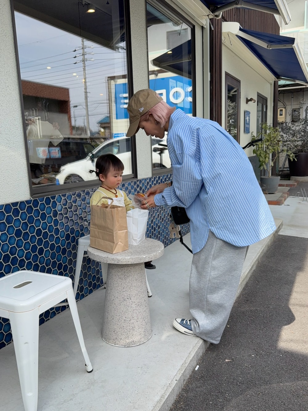 ブルー系のシャツ/ブラウス、ブルー系のスニーカー、ベージュ系のキャップを着用したレディースの春コーディネートの4枚目の写真