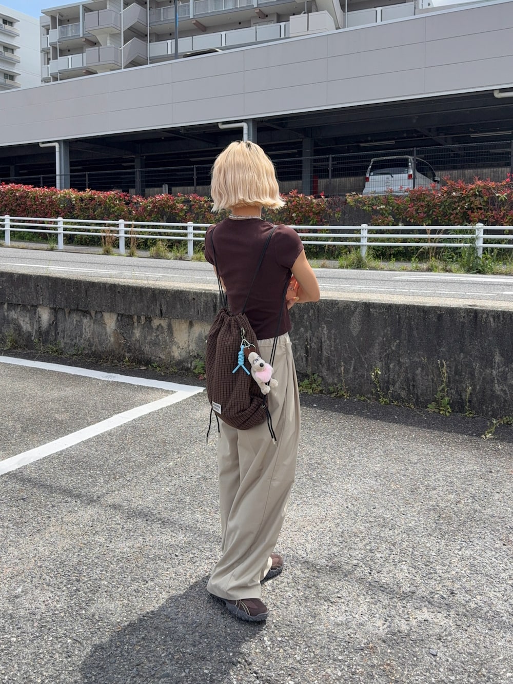 ブラウン系のバックパック/リュック、ブラック系のTシャツ/カットソー、ブラウン系のスニーカーを着用したレディースの春コーディネートの4枚目の写真