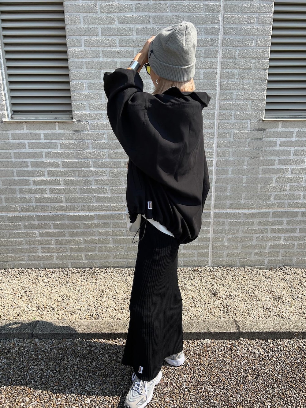 ホワイト系のTシャツ/カットソー、グリーン系のショルダーバッグ、ブラック系のスカートを着用したレディースの秋コーディネートの2枚目の写真