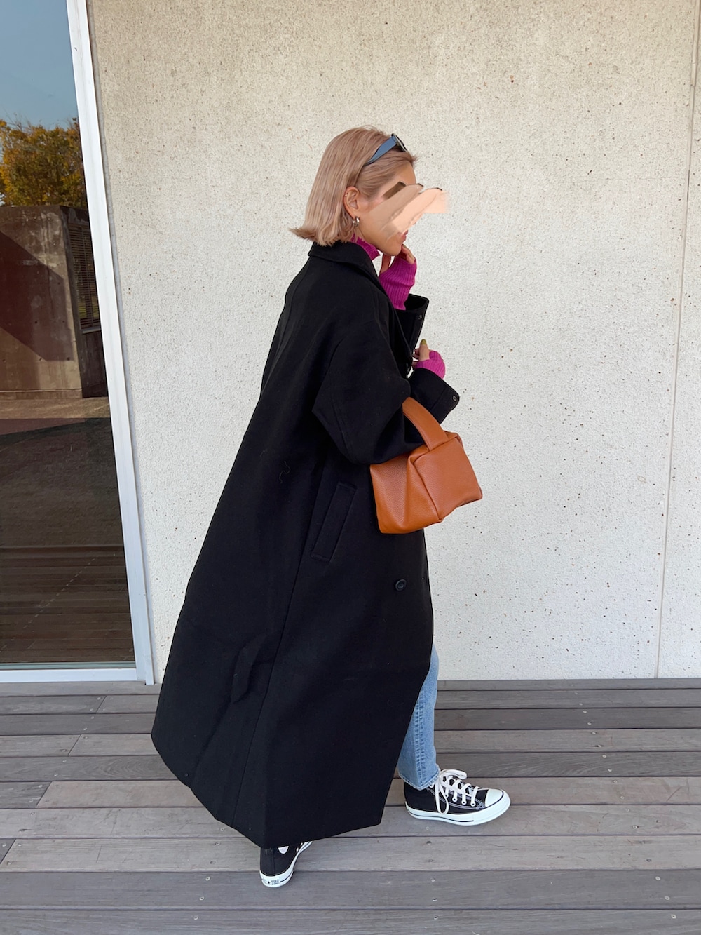 ブラック系のその他アウター、ピンク系のニット/セーター、ブルー系のデニムパンツを着用したレディースの秋コーディネートの3枚目の写真