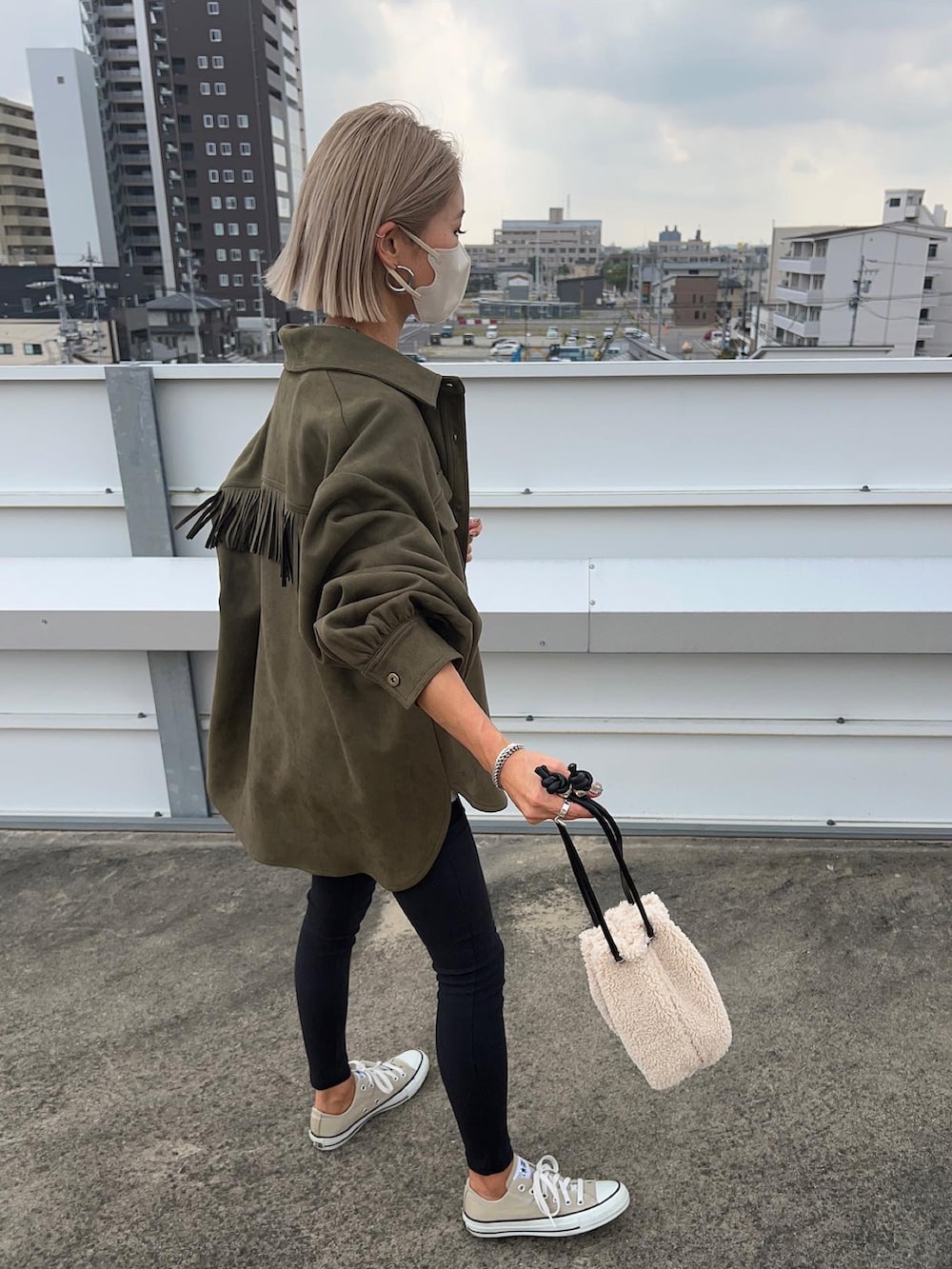 グリーン系のミリタリージャケット、ベージュ系のバッグを着用したレディースの秋コーディネートの3枚目の写真