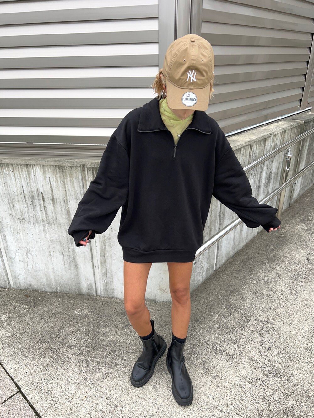 ブラック系のスウェット、グリーン系のTシャツ/カットソー、ブラック系のブーツを着用したレディースの秋コーディネートの5枚目の写真