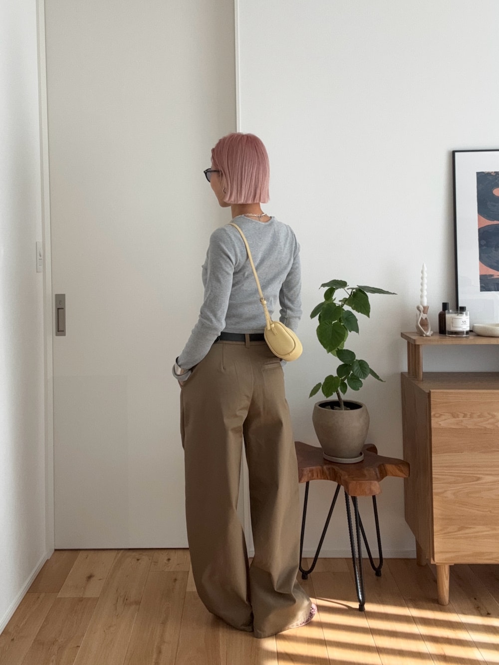グレー系のTシャツ/カットソー、イエロー系のショルダーバッグ、ベージュ系のチノパンツを着用したレディースの冬コーディネートの3枚目の写真