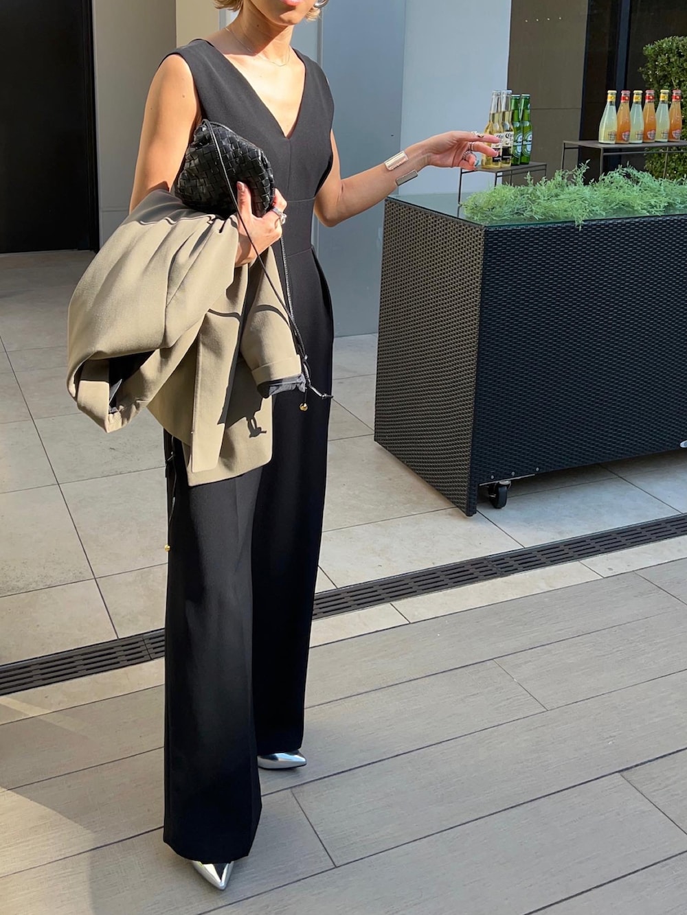 グリーン系のテーラードジャケット、ブラック系のパンツドレス、ブラック系のチェスターコートを着用したレディースの冬コーディネートの3枚目の写真