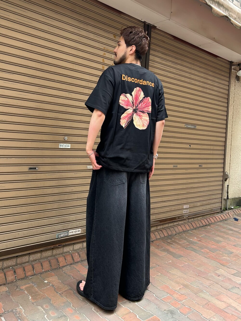 ブラック系のTシャツ/カットソー、ブラック系のパンツ、ブラック系のシューズを着用したメンズの春コーディネートの2枚目の写真