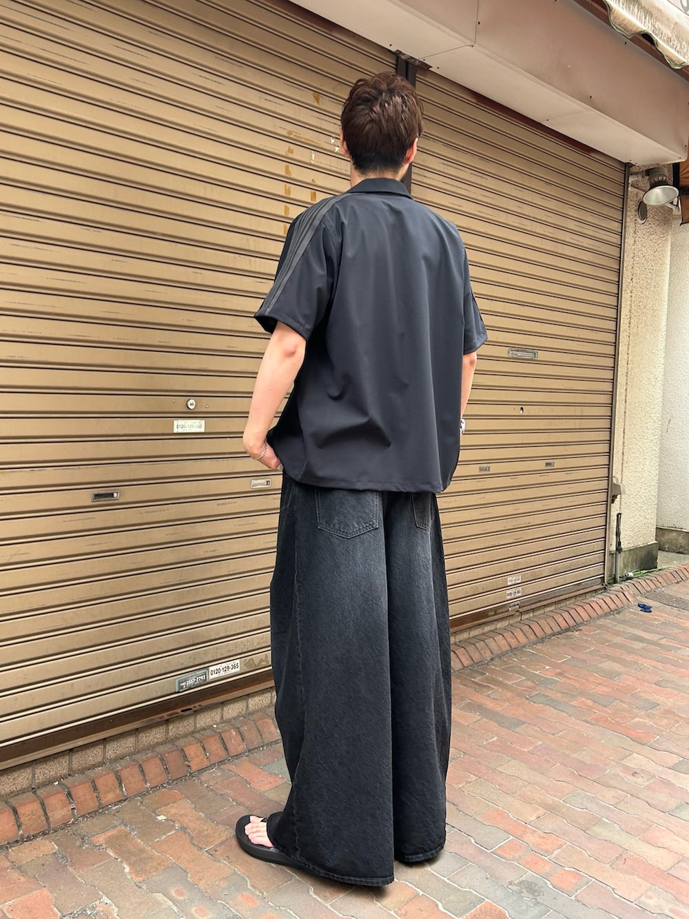 ブラック系のシャツ/ブラウス、ブラック系のパンツ、ブラック系のシューズを着用したメンズの春コーディネートの2枚目の写真