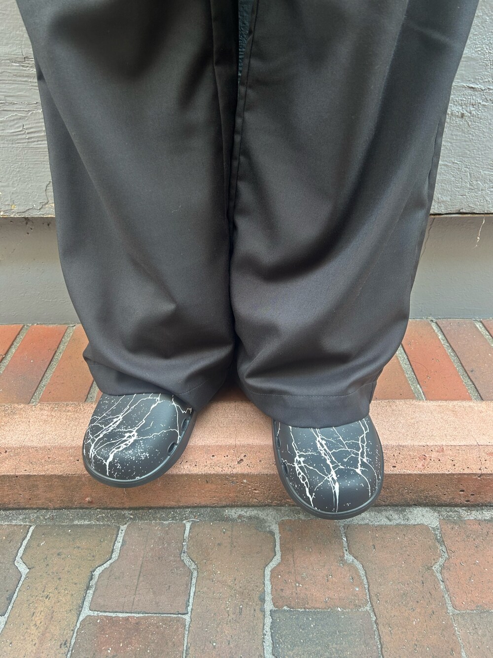 ブラック系のチノパンツ、ブラック系のサンダルを着用したメンズの秋コーディネートの4枚目の写真