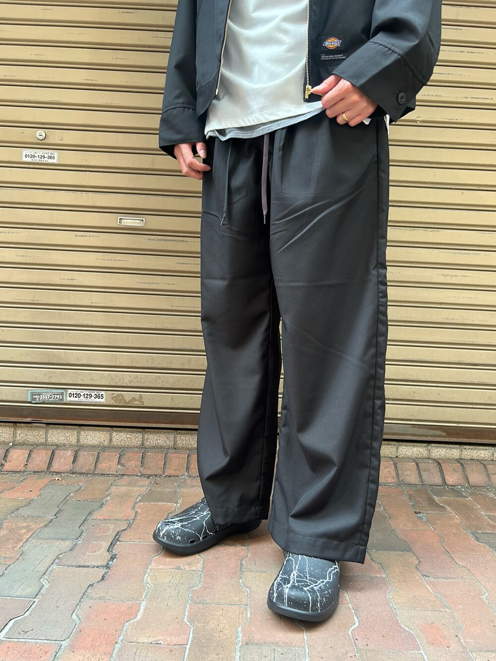 ブラック系のチノパンツ、ブラック系のサンダル、ホワイト系のTシャツ/カットソーを着用したメンズの秋コーディネートの3枚目の写真