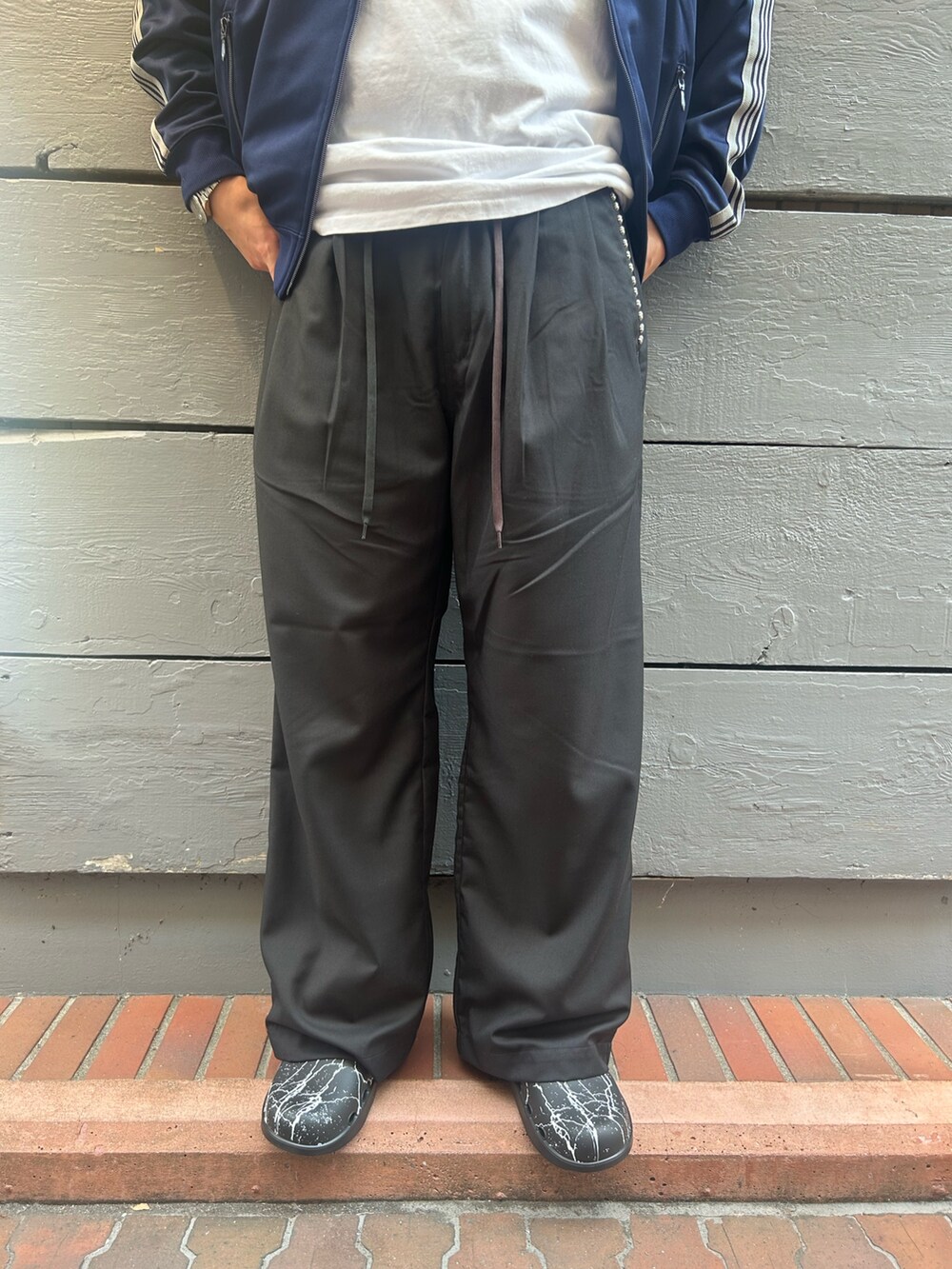 ブラック系のチノパンツ、ブラック系のサンダルを着用したメンズの秋コーディネートの3枚目の写真