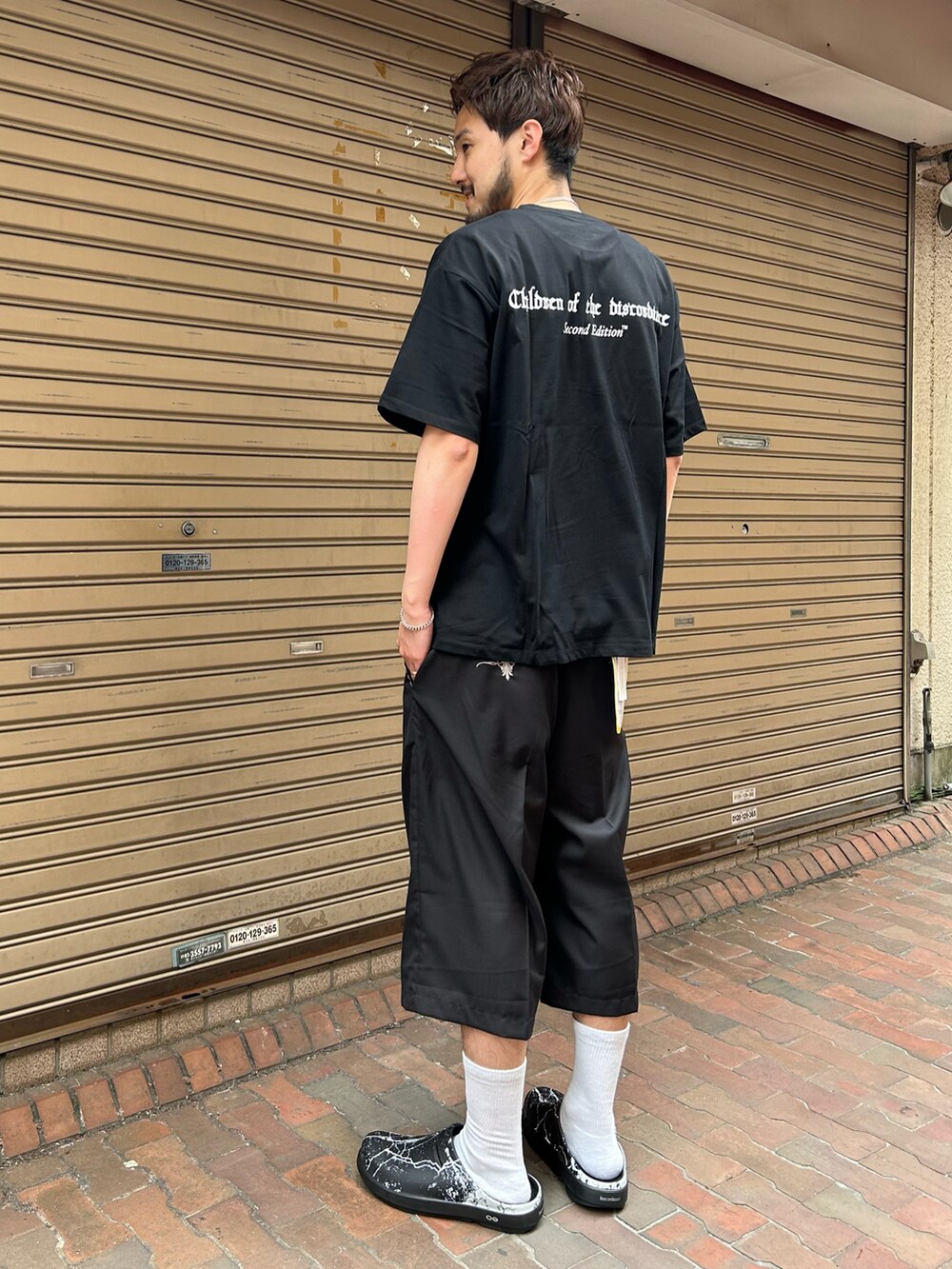 ブラック系のその他パンツ、ブラック系のTシャツ/カットソー、ブラック系のサンダルを着用したメンズの春コーディネートの2枚目の写真