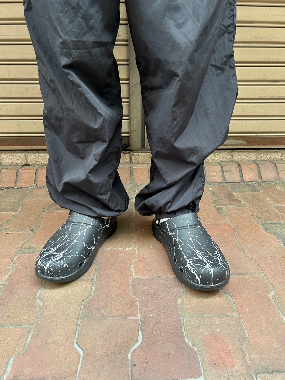 ブラック系のその他アウター、ブラック系のサンダルを着用したメンズの秋コーディネートの3枚目の写真