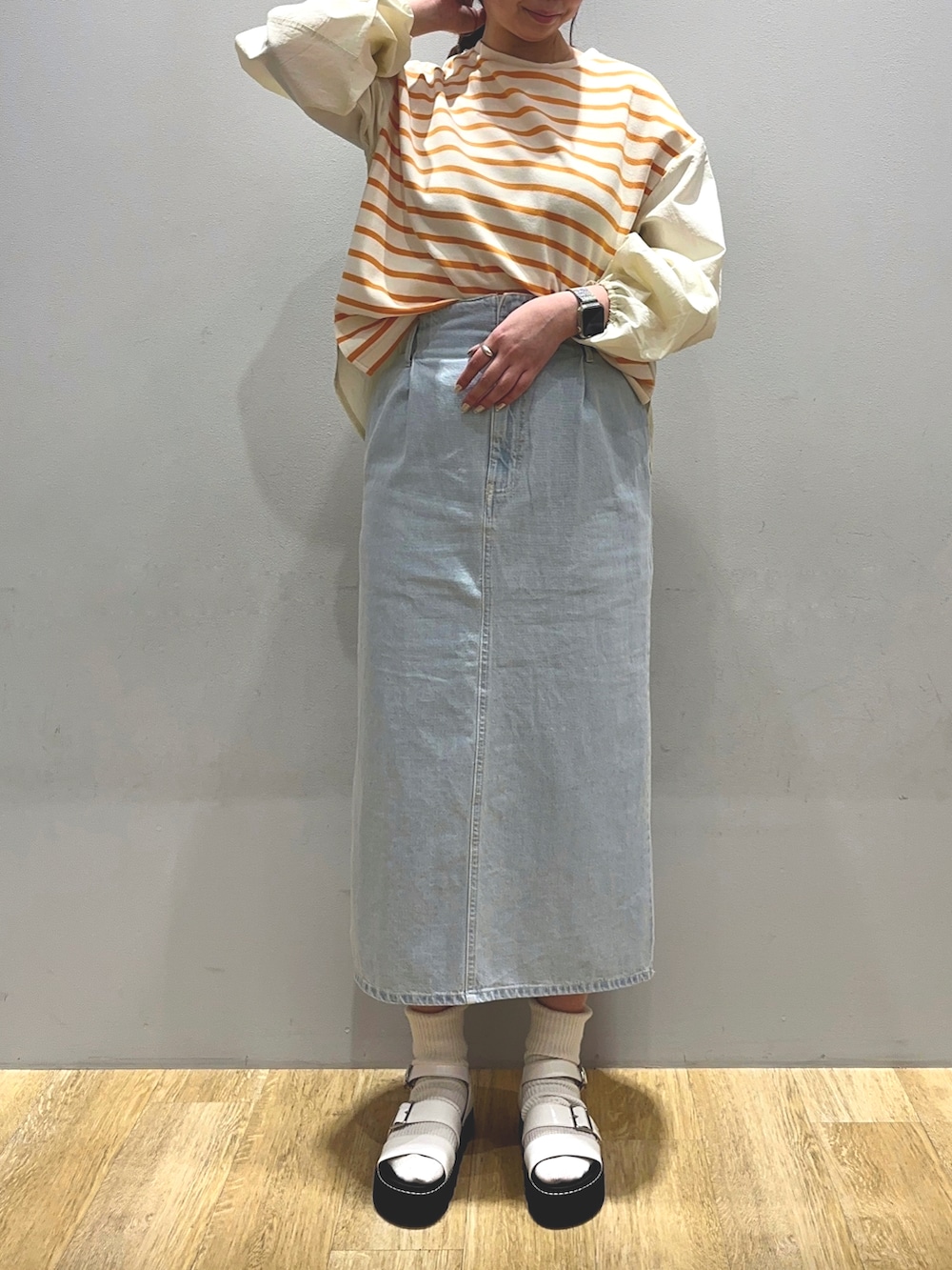 イエロー系のTシャツ/カットソー、ブルー系のスカートを着用したレディースの冬コーディネートの2枚目の写真