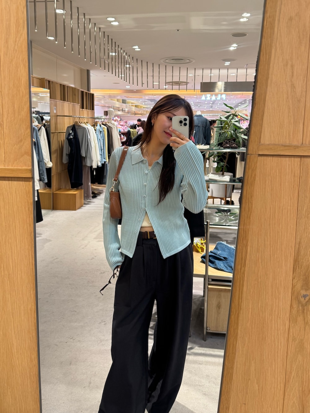 ブルー系のカーディガン/ボレロ、ブラウン系のハンドバッグを着用したレディースの春コーディネートの2枚目の写真