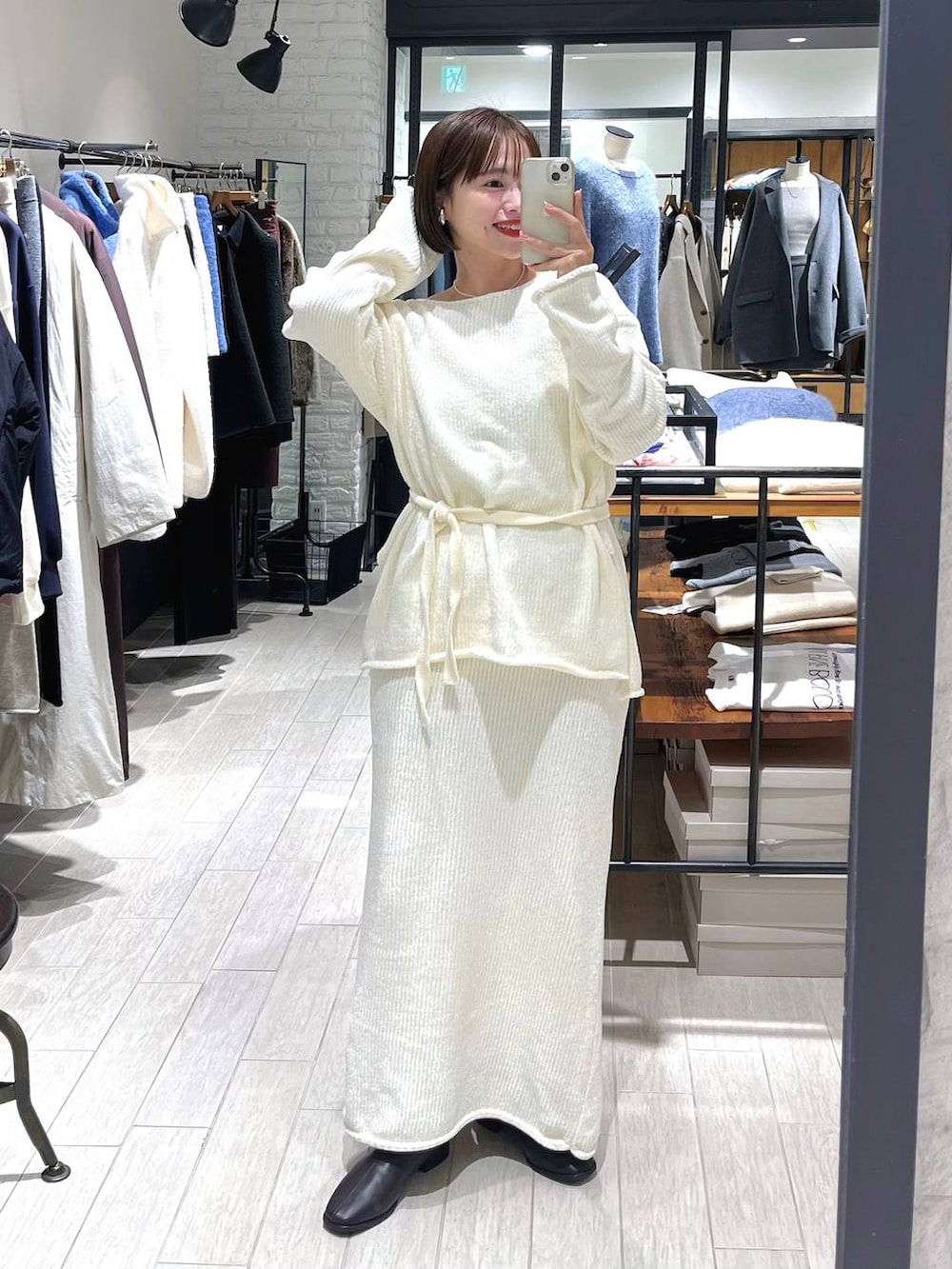 ブラウン系のブーツ、ホワイト系のセットアップ、ホワイト系のネックレスを着用したレディースの秋コーディネートの2枚目の写真