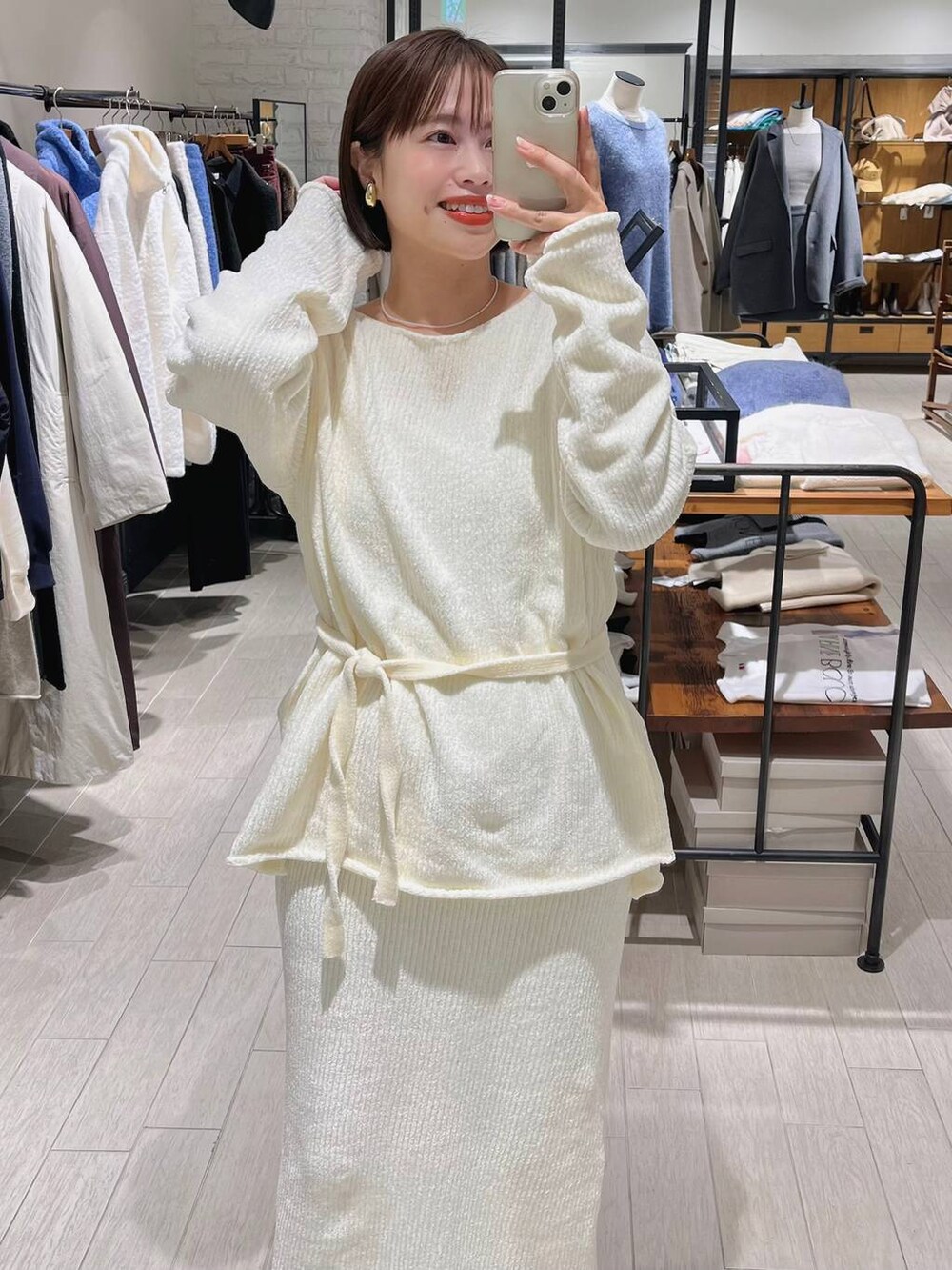 ブラウン系のブーツ、ホワイト系のセットアップ、ホワイト系のネックレスを着用したレディースの秋コーディネートの3枚目の写真