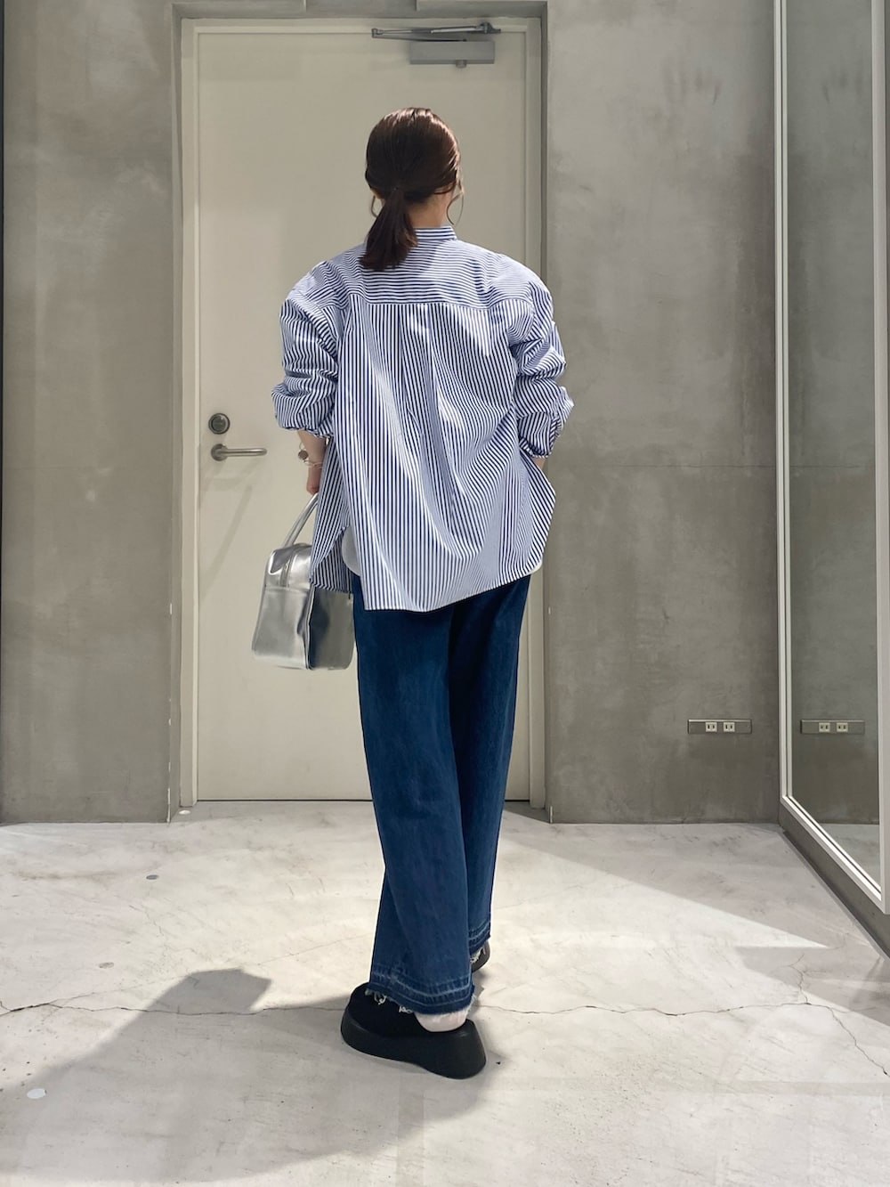 ホワイト系のTシャツ/カットソー、ブルー系のシャツ/ブラウス、シルバー系のボストンバッグを着用したレディースの春コーディネートの5枚目の写真