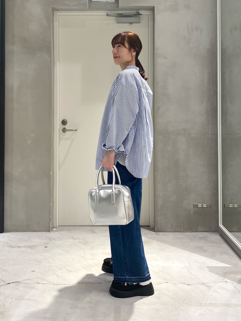 ホワイト系のTシャツ/カットソー、ブルー系のシャツ/ブラウス、シルバー系のボストンバッグを着用したレディースの春コーディネートの4枚目の写真