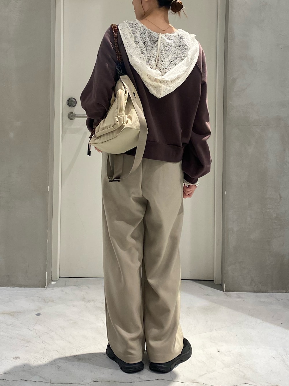 ブラウン系のスウェット、ホワイト系のTシャツ/カットソー、ベージュ系のスラックスを着用したレディースの秋コーディネートの3枚目の写真