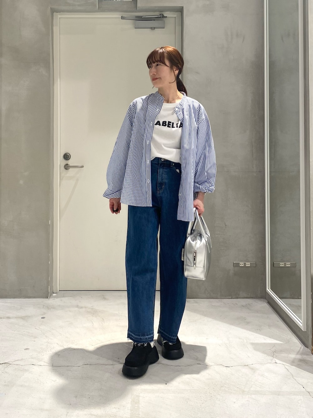 ホワイト系のTシャツ/カットソー、ブルー系のシャツ/ブラウス、シルバー系のボストンバッグを着用したレディースの春コーディネートの2枚目の写真