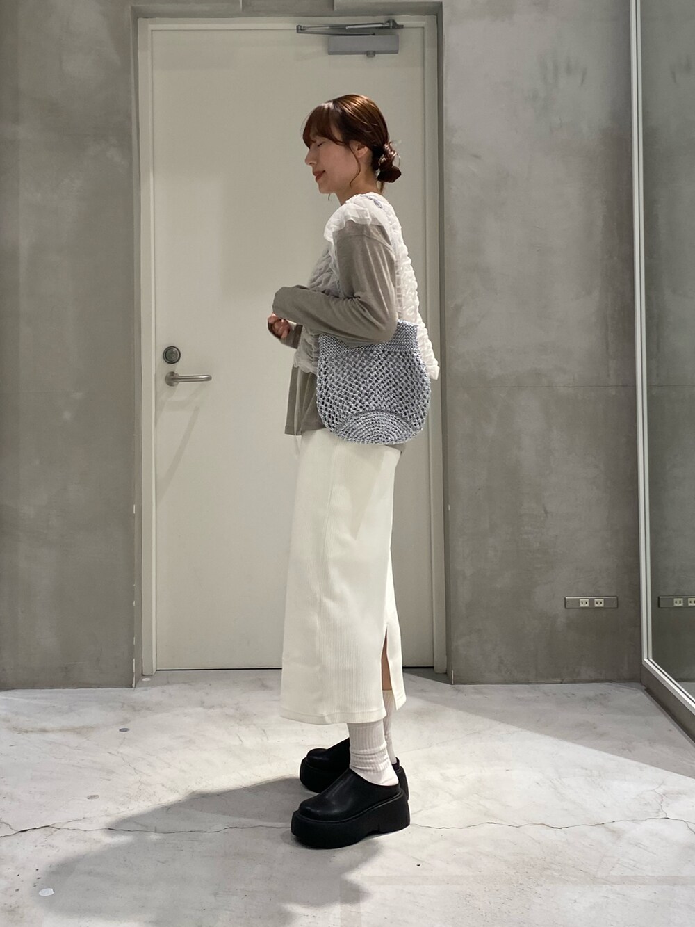 ホワイト系のベスト、シルバー系のトートバッグ、ベージュ系のTシャツ/カットソーを着用したレディースの春コーディネートの2枚目の写真