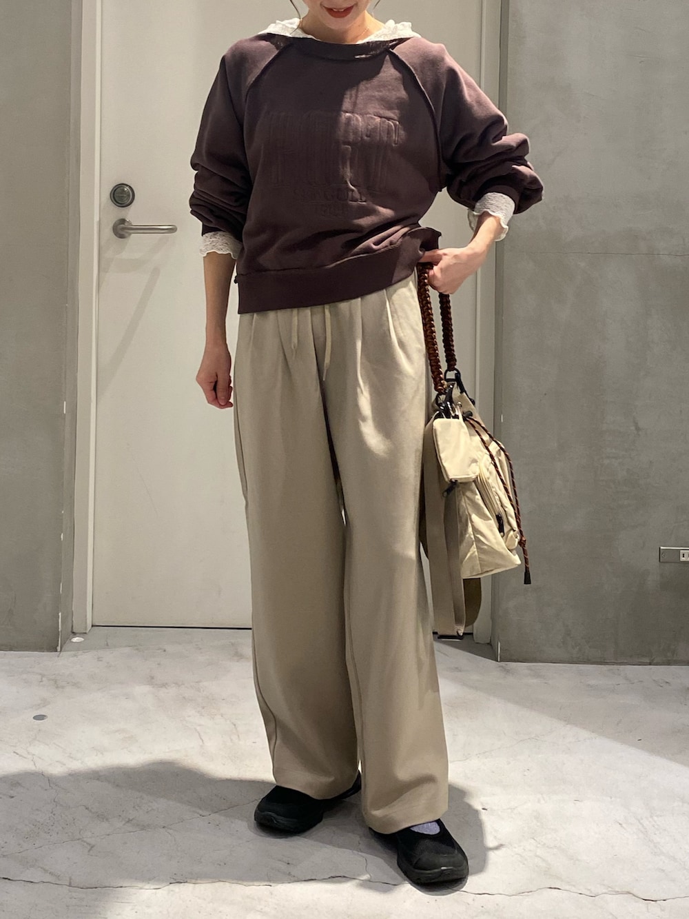 ブラウン系のスウェット、ホワイト系のTシャツ/カットソー、ベージュ系のスラックスを着用したレディースの秋コーディネートの4枚目の写真