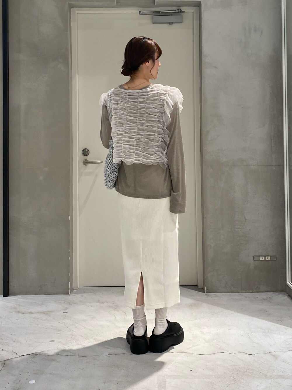 ホワイト系のベスト、シルバー系のトートバッグ、ベージュ系のTシャツ/カットソーを着用したレディースの春コーディネートの3枚目の写真