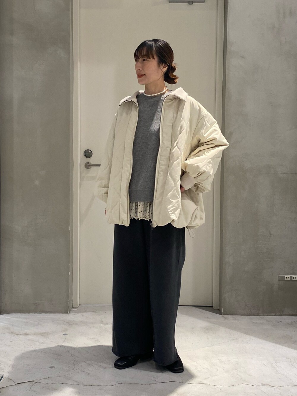ホワイト系のブルゾン、グレー系のスウェットパンツ、ホワイト系のTシャツ/カットソーを着用したレディースの冬コーディネートの4枚目の写真