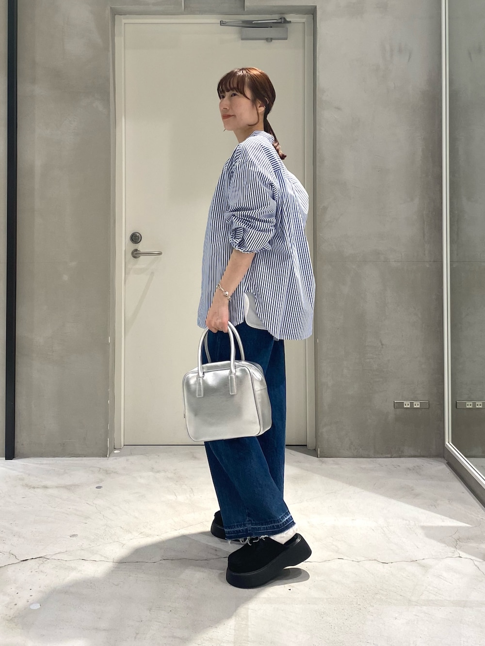 ホワイト系のTシャツ/カットソー、ブルー系のシャツ/ブラウス、シルバー系のボストンバッグを着用したレディースの春コーディネートの3枚目の写真