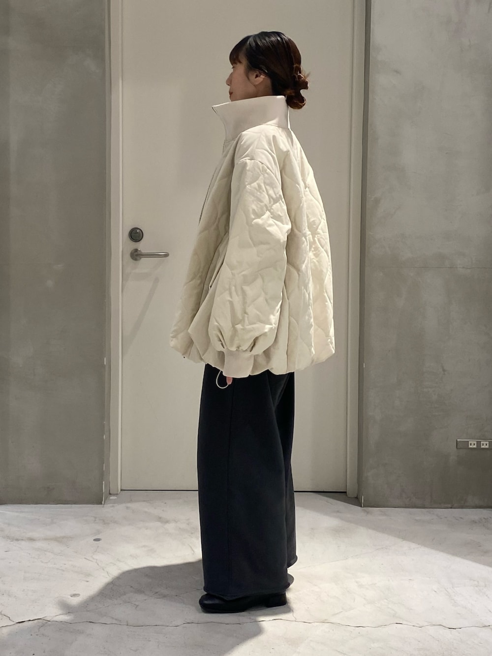 ホワイト系のブルゾン、グレー系のスウェットパンツ、ホワイト系のTシャツ/カットソーを着用したレディースの冬コーディネートの2枚目の写真