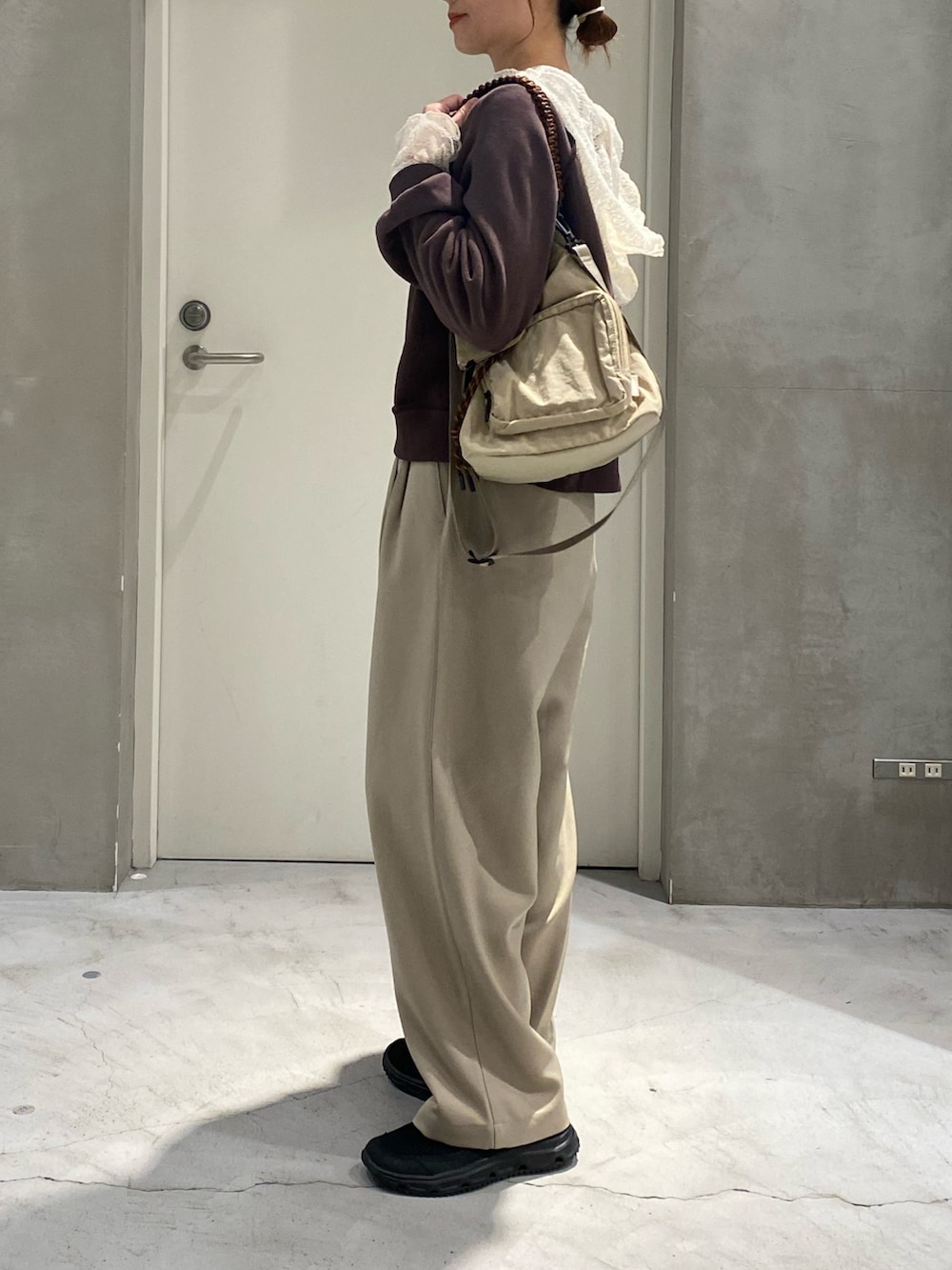 ブラウン系のスウェット、ホワイト系のTシャツ/カットソー、ベージュ系のスラックスを着用したレディースの秋コーディネートの2枚目の写真