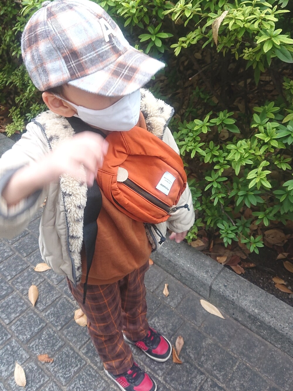 ブラウン系のボディバッグ/ウエストポーチ、ベージュ系のジャケット/アウター、ブラウン系のパンツを着用したレディースの冬コーディネートの2枚目の写真