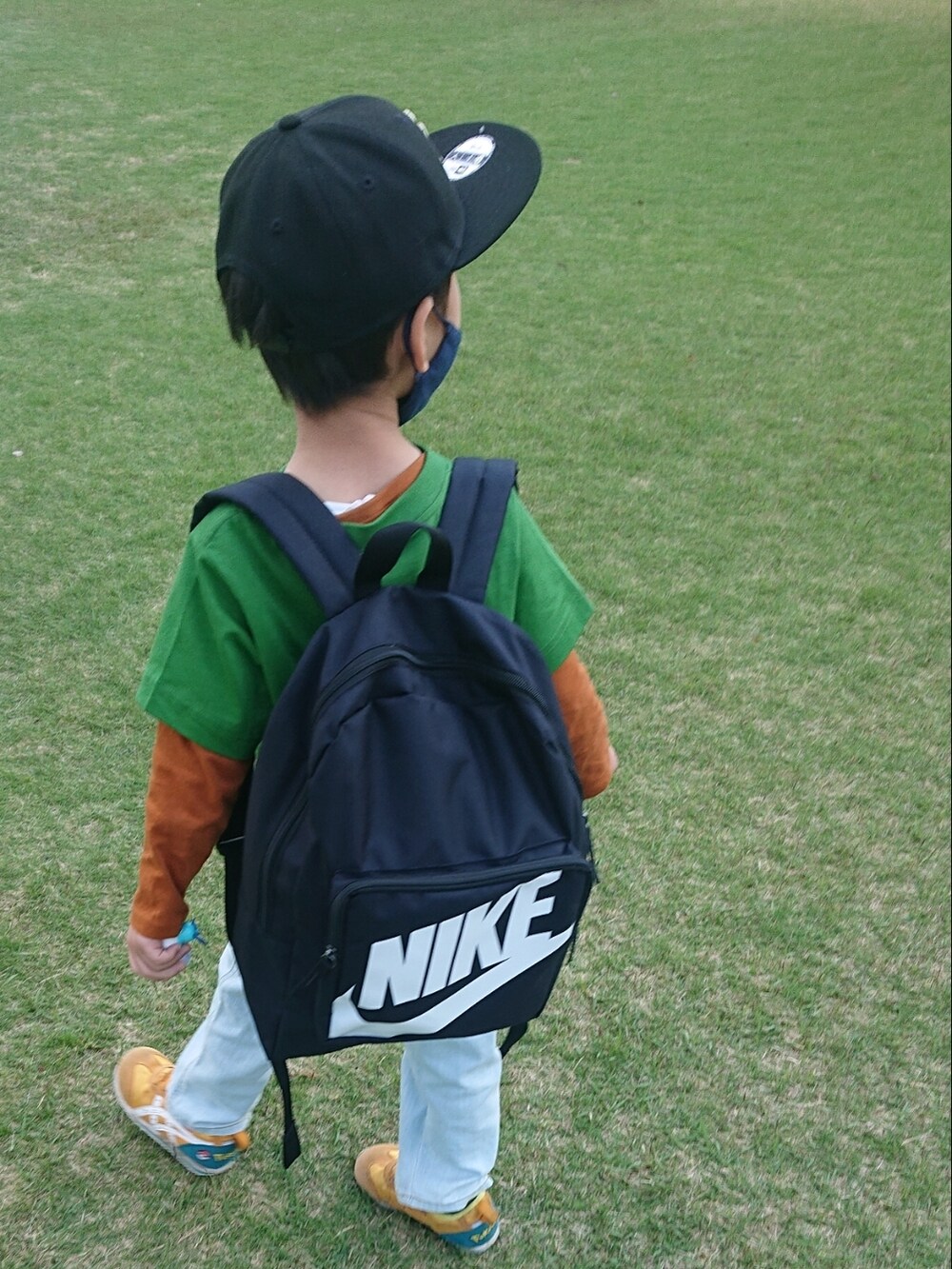 ブルー系のバックパック/リュック、ブルー系のデニムパンツ、イエロー系のシャツ/ブラウスを着用したレディースの春コーディネートの3枚目の写真