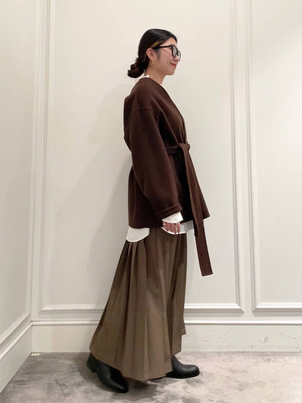 ブラウン系のノーカラージャケット、ブラウン系のスカート、ホワイト系のシャツ/ブラウスを着用したレディースの冬コーディネートの5枚目の写真