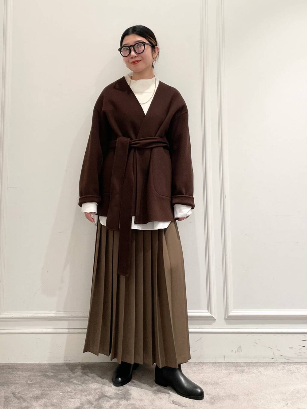 ブラウン系のノーカラージャケット、ブラウン系のスカート、ホワイト系のシャツ/ブラウスを着用したレディースの冬コーディネートの3枚目の写真