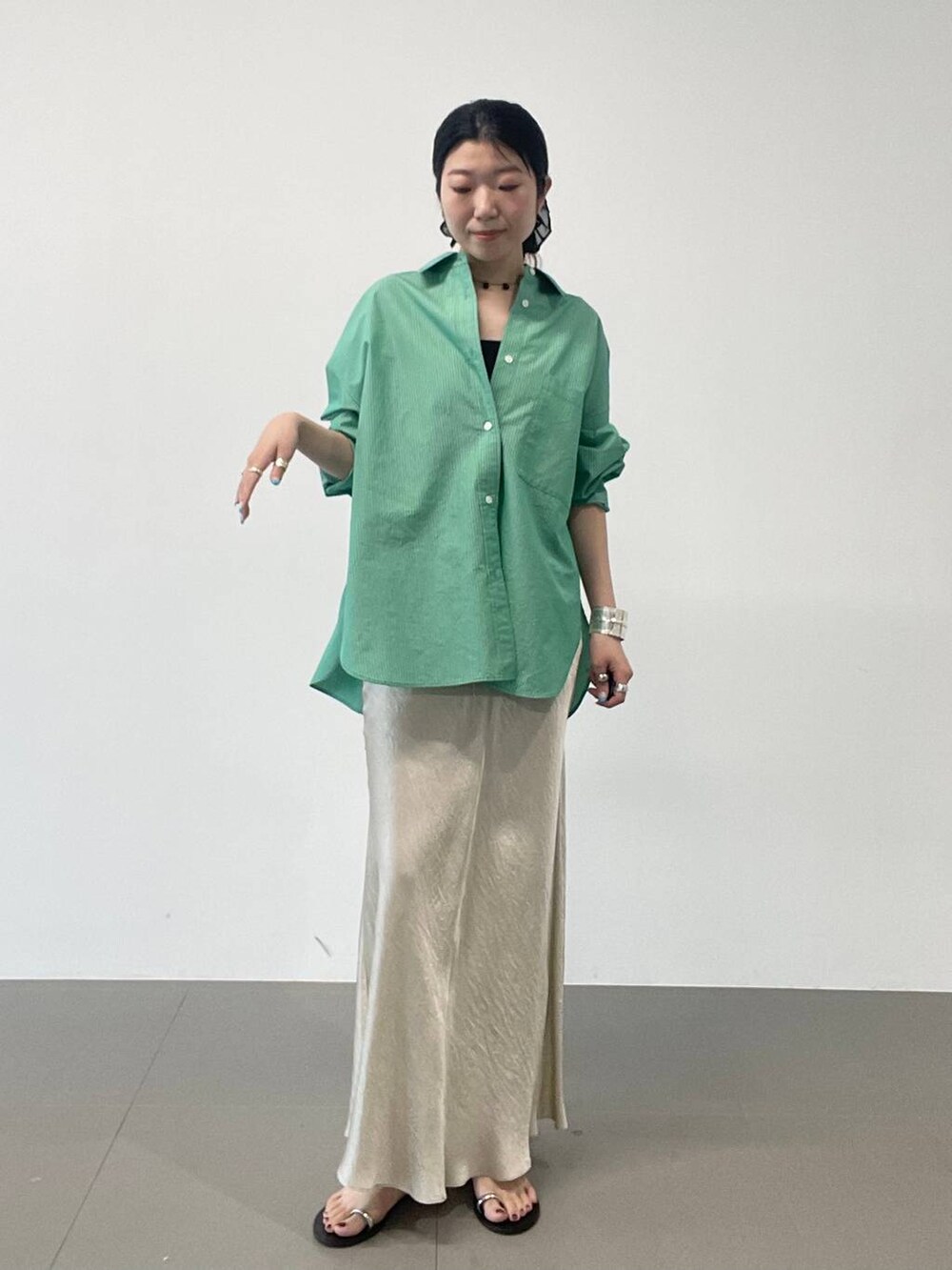 ブラック系のサンダル、ゴールド系のスカート、グリーン系のシャツ/ブラウスを着用したレディースの夏コーディネートの3枚目の写真