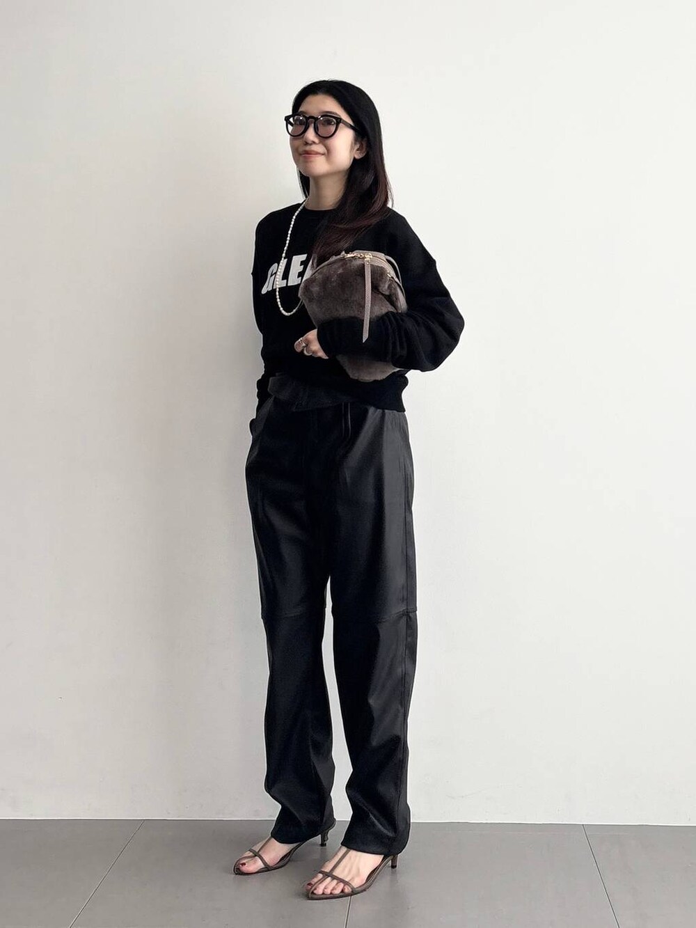 ベージュ系のサンダル、ベージュ系のハンドバッグ、ブラック系のその他パンツを着用したレディースの秋コーディネートの3枚目の写真