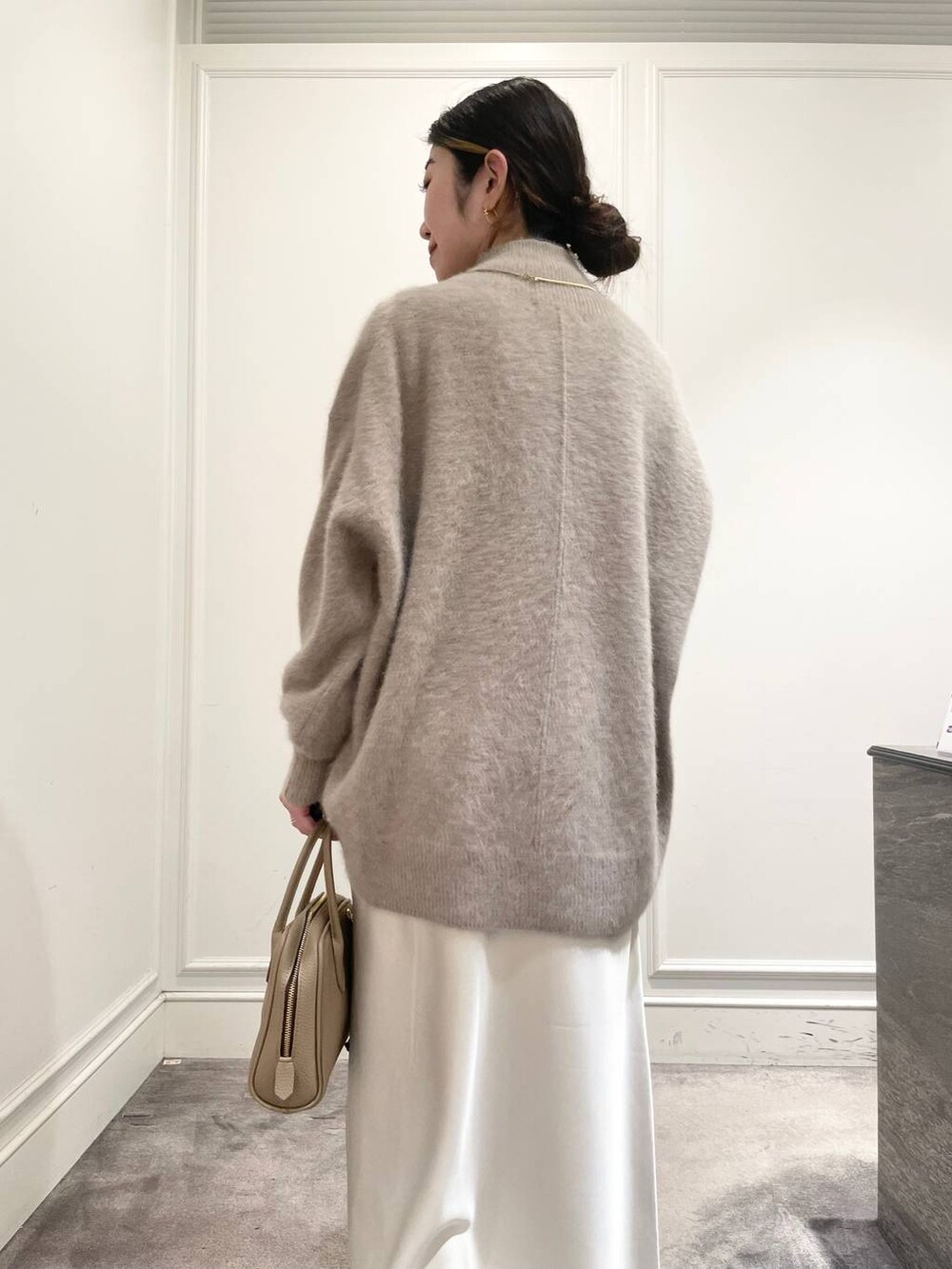 ホワイト系のスカート、ブラウン系のニット/セーターを着用したレディースの冬コーディネートの9枚目の写真