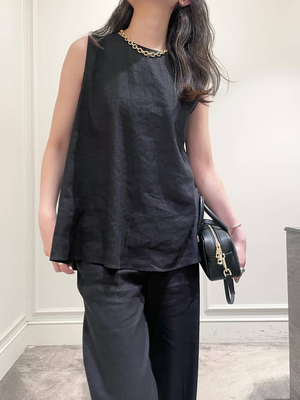 ブラック系のショルダーバッグ、ブラウン系のサンダル、グレー系のシャツ/ブラウスを着用したレディースの夏コーディネートの7枚目の写真