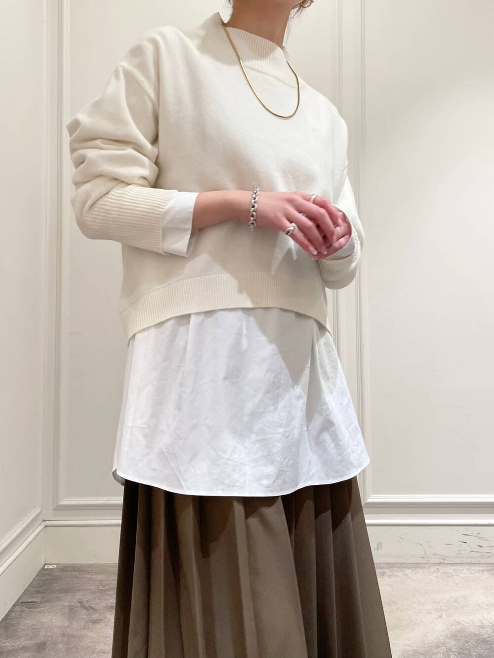 ブラック系のショルダーバッグ、ブラウン系のスカート、ホワイト系のシャツ/ブラウスを着用したレディースの冬コーディネートの8枚目の写真