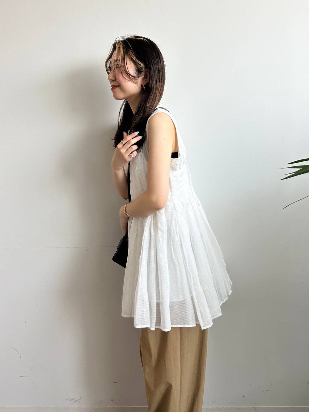 ホワイト系のタンクトップ、ホワイト系のキャミソール、ブラック系のキャミソールを着用したレディースの夏コーディネートの8枚目の写真
