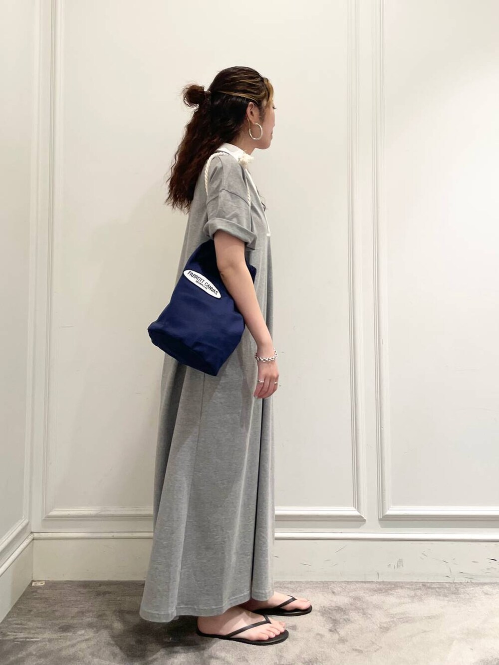 グレー系のワンピース、ブルー系のハンドバッグ、ブラック系のキャミソールを着用したレディースの夏コーディネートの3枚目の写真