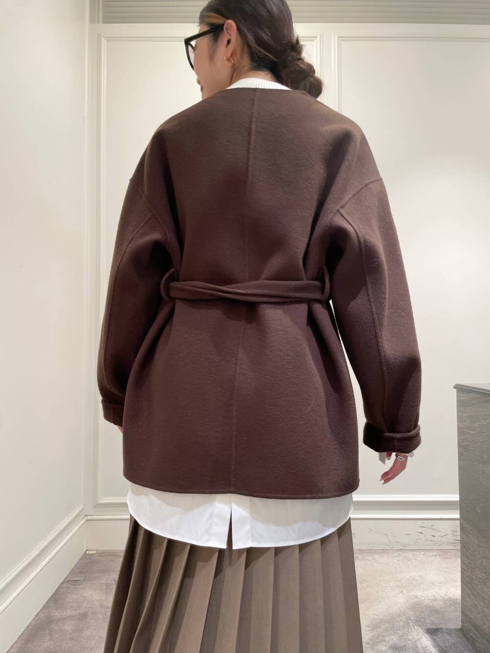 ブラウン系のノーカラージャケット、ブラウン系のスカート、ホワイト系のシャツ/ブラウスを着用したレディースの冬コーディネートの9枚目の写真