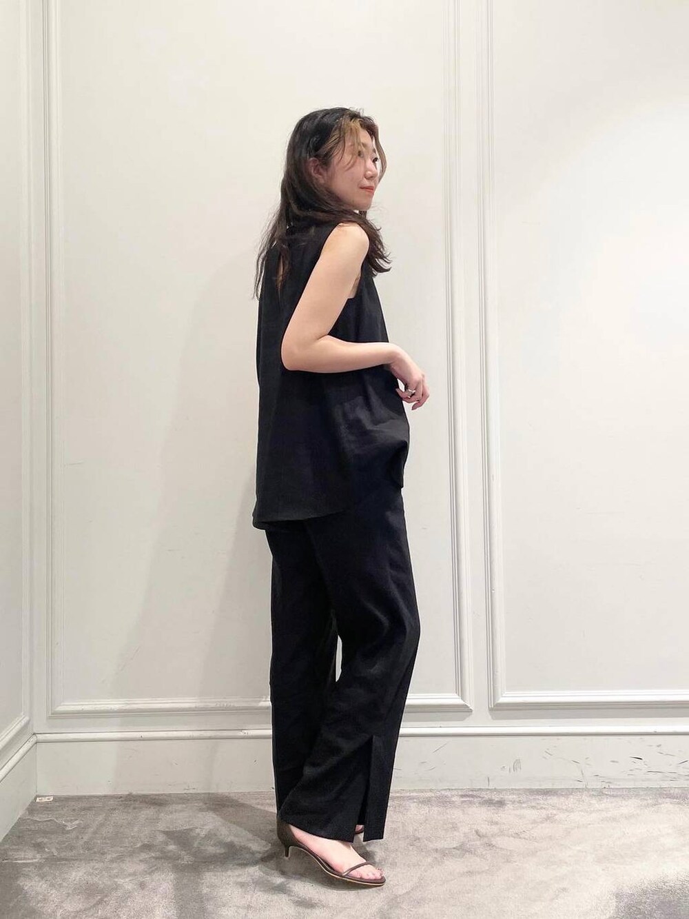 ブラック系のショルダーバッグ、ブラウン系のサンダル、グレー系のシャツ/ブラウスを着用したレディースの夏コーディネートの2枚目の写真