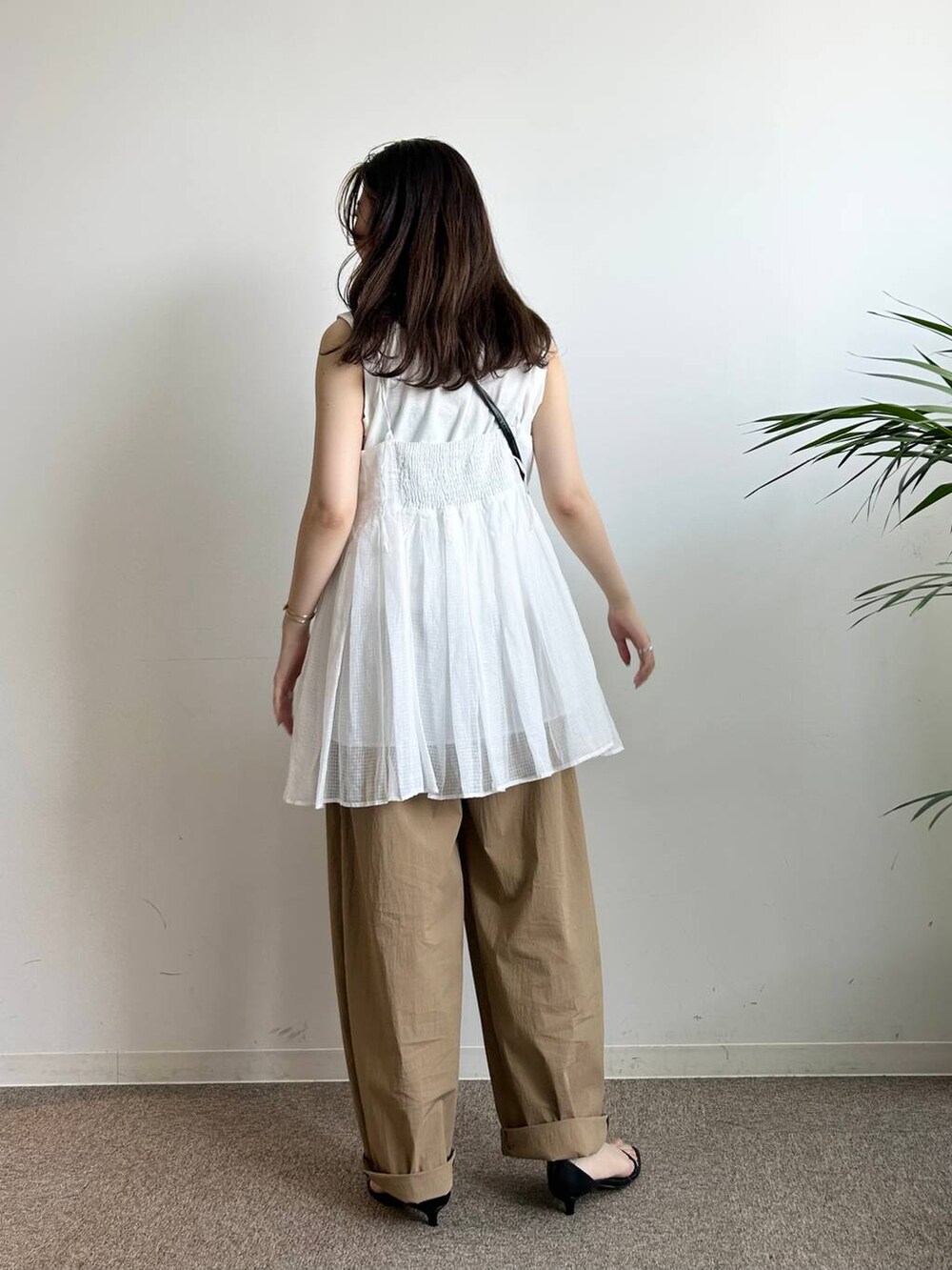 ホワイト系のタンクトップ、ホワイト系のキャミソール、ブラック系のキャミソールを着用したレディースの夏コーディネートの5枚目の写真