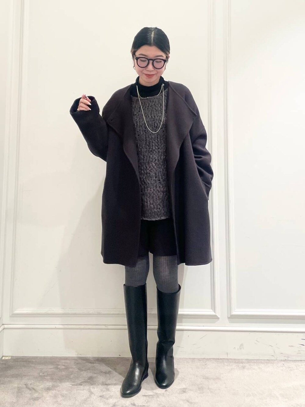 グレー系のピーコート、ブラック系のTシャツ/カットソー、グレー系のニット/セーターを着用したレディースの冬コーディネートの2枚目の写真