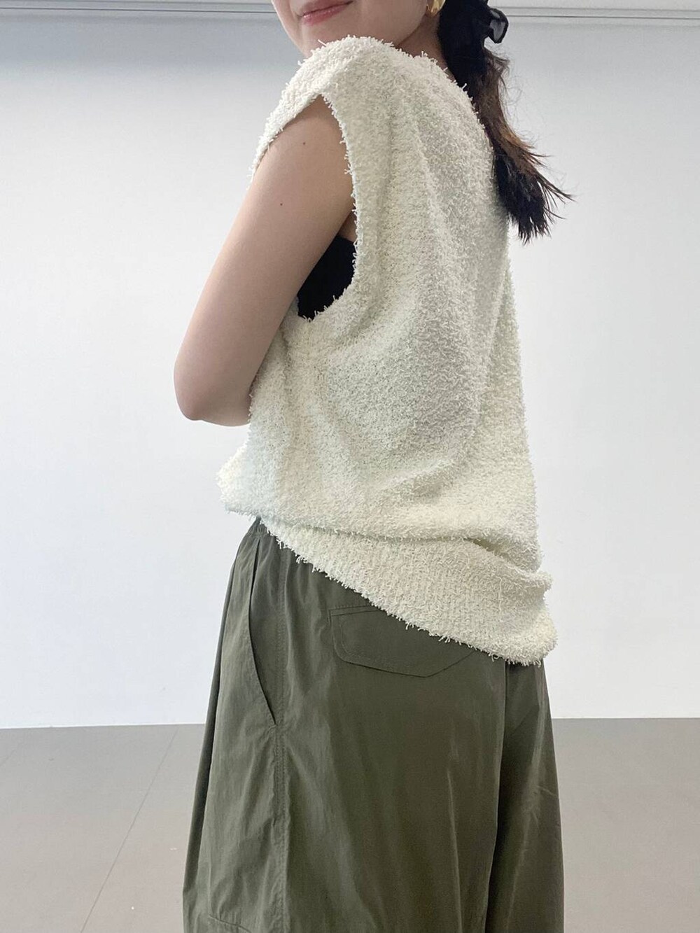 ゴールド系のパンプス、グリーン系のカーゴパンツ、ホワイト系のニット/セーターを着用したレディースの夏コーディネートの8枚目の写真