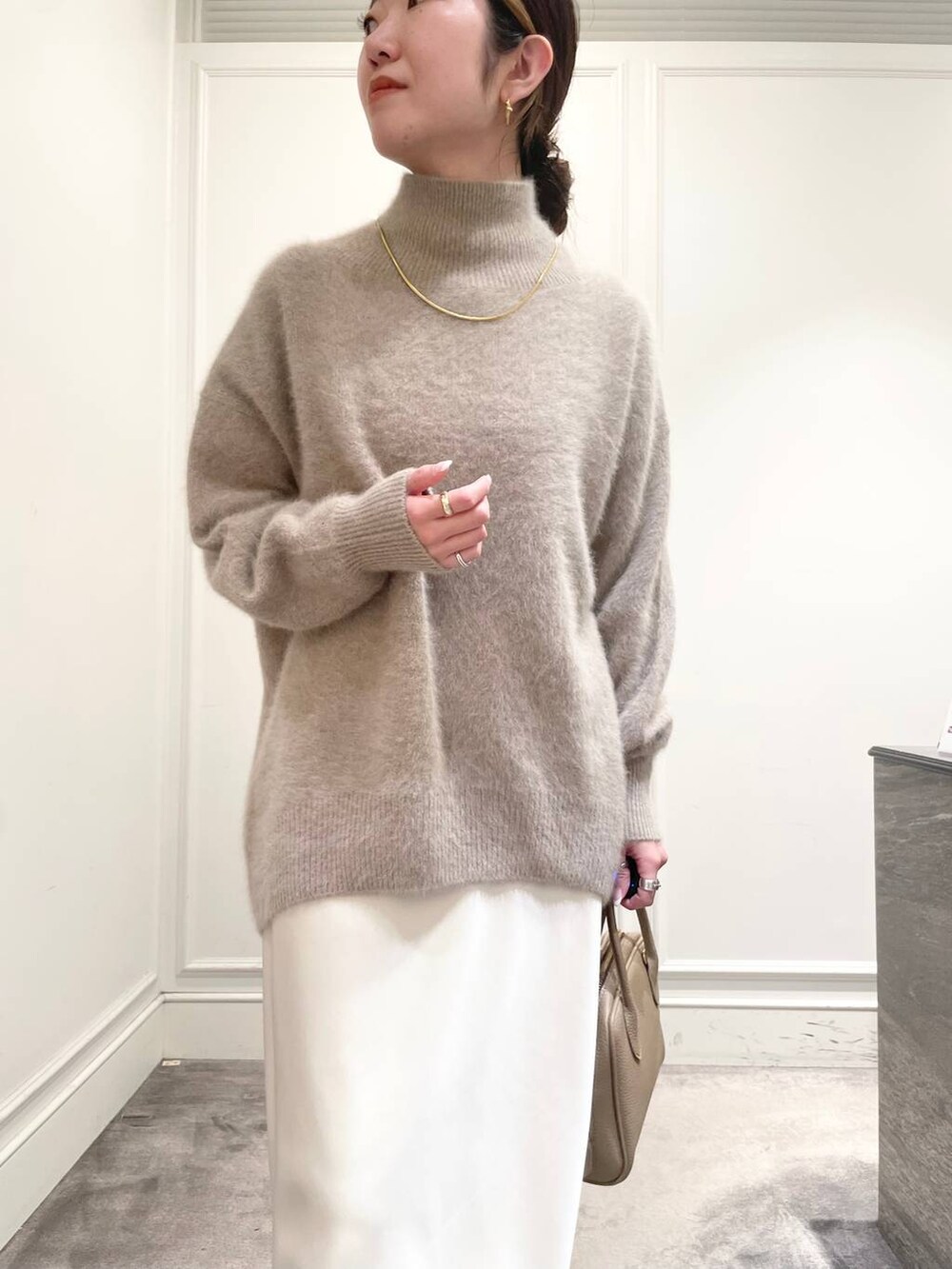 ホワイト系のスカート、ブラウン系のニット/セーターを着用したレディースの冬コーディネートの6枚目の写真