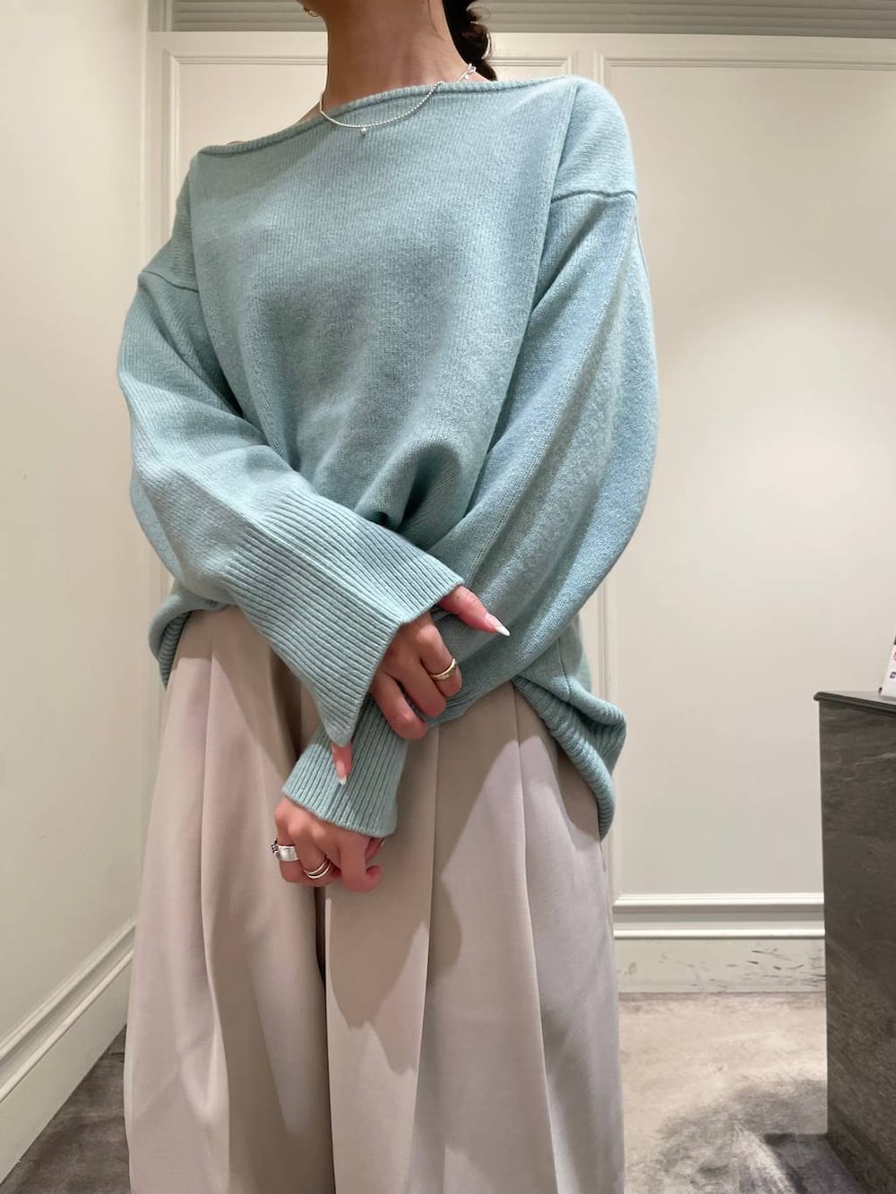 グリーン系のニット/セーター、ベージュ系のその他パンツ、ブラック系のショルダーバッグを着用したレディースの冬コーディネートの9枚目の写真