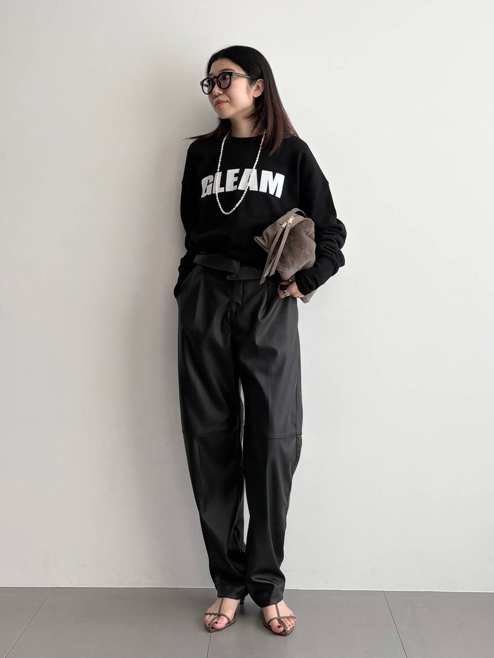 ベージュ系のサンダル、ベージュ系のハンドバッグ、ブラック系のその他パンツを着用したレディースの秋コーディネートの2枚目の写真